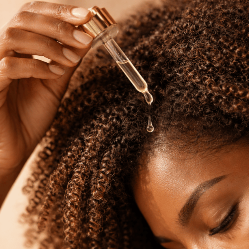 Une femme afro qui a un droplet qui signifie les soins sans rinçage pour les cheveux texturés chez Ladies univers en France